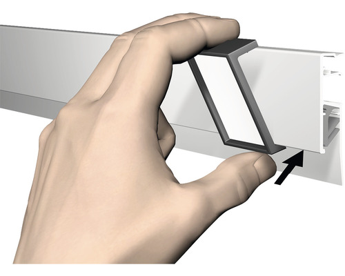 Hand bevestigt een metalen rail aan een wandlijst