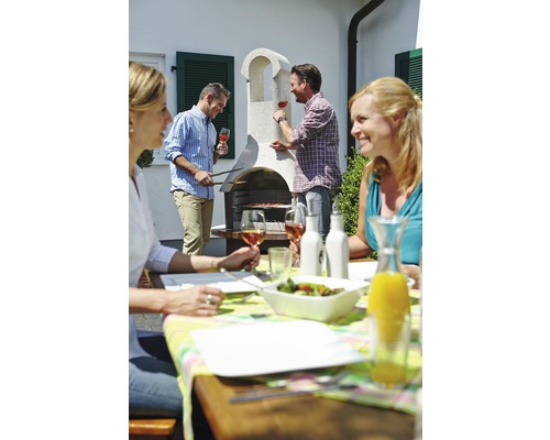 Groep mensen die aan het barbecueën is in de tuin met een gemetselde barbecue en tuintafel