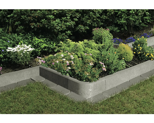 Betonnen border met beplanting in de tuin.