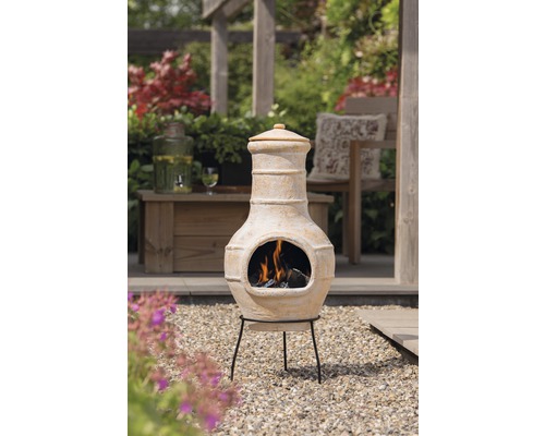 Terrasverwarmer van terracotta met stalen frame in een buitenomgeving.