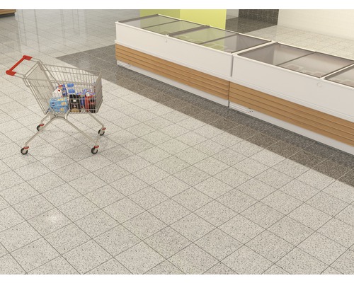 Winkelwagen gevuld met producten naast een koelmeubel in een supermarkt.