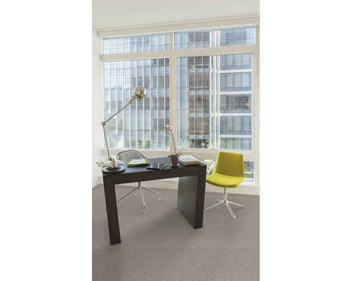 Kantoorruimte met bureau, bureaustoel, lamp en raam met uitzicht op een gebouw