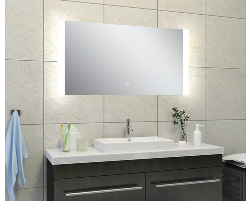 Badkamer met verlichte spiegel, wastafel en onderkast.