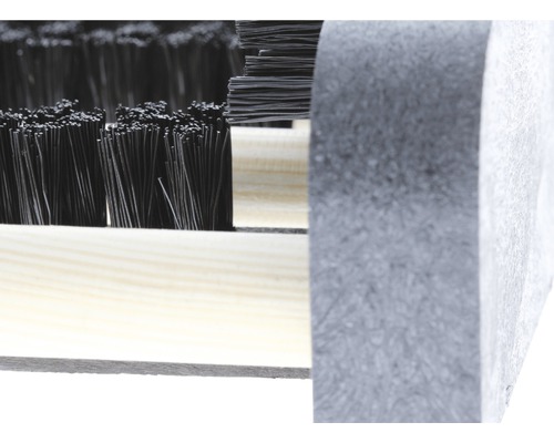 Close-up van een deurmat met borstelharen en houten frame