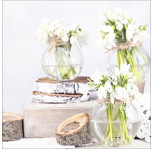 Drie glazen vazen met sneeuwklokjes op houten schijven