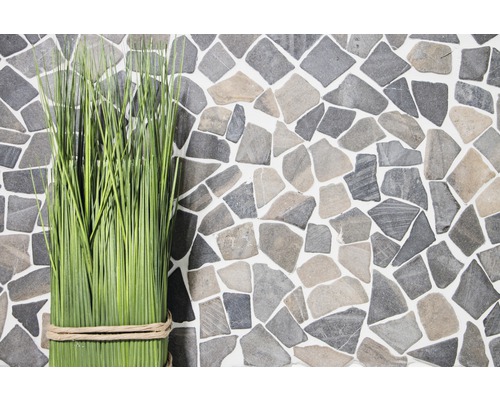 Decoratieve grassprieten voor een muur van imitatiesteen.