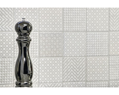 Wanddecoratie met verschillende decoratieve tegels en pepermolen