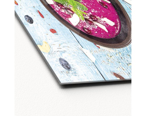 Close-up van een acrylglasfoto met een kom soep op een houten tafel