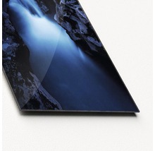 Close-up van een glasplaat met een waterval tussen rotsen