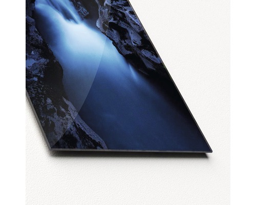 Close-up van een glasplaat met een waterval tussen rotsen