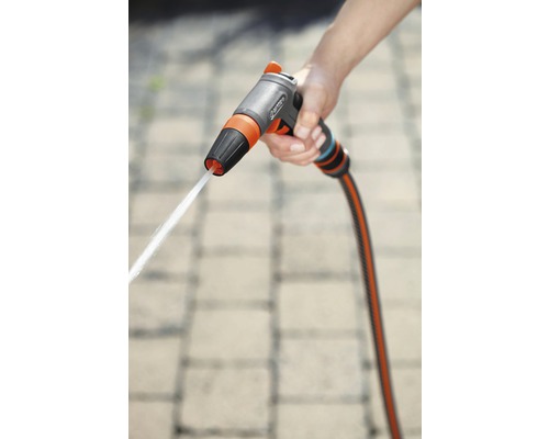 Een hand houdt een tuinspuit met waterstraal vast.