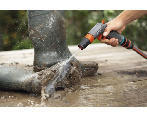 Vuile rubberlaarzen worden gereinigd met een Gardena reinigingsspuit