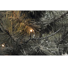 Close-up van een verlichte, besneeuwde dennenboom slinger.