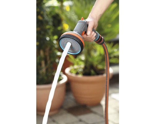Persoon houdt een Gardena multifunctionele broes vast met waterstraal