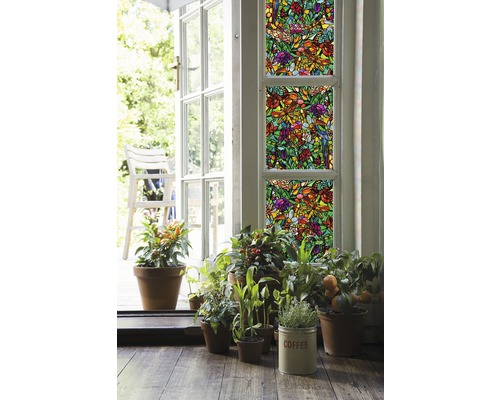 Decoratieve folie met plantenmotief op ramen, omringd door potplanten en een open deur