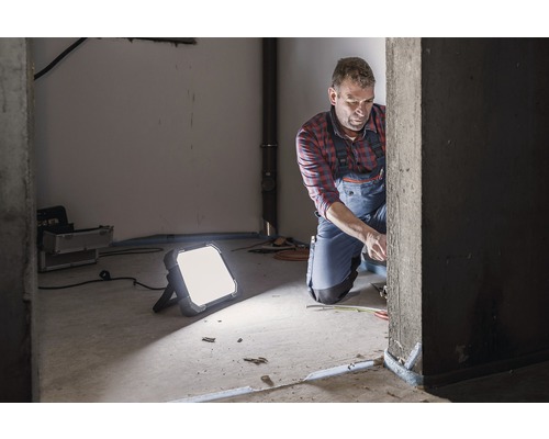 Ambachtsman aan het werk met bouwlamp voor verlichting