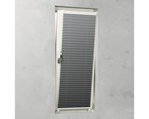 Grijze plissés aan het raam voor zonwering