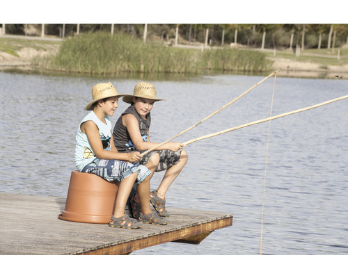 Twee jongens zitten met hengels op een steiger aan een meer.