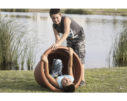 Twee jongens spelen buiten met een grote plantenbak.