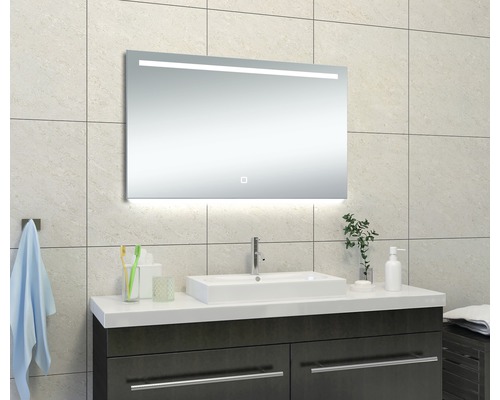 Badkamerscène met verlichte spiegel boven een wastafel