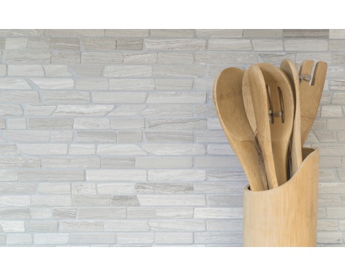 Houten keukengerei in een houder voor een stenen muur