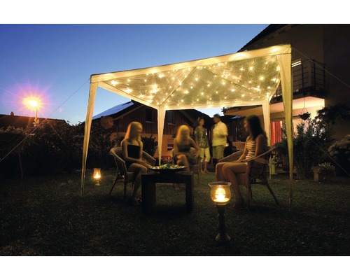 Tuinscene met partytent, lichtslingers en zittende personen
