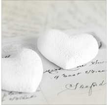 Twee witte papieren harten op papier