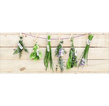 Kruiden zoals rozemarijn, basilicum, bieslook, tijm en salie hangen aan een touw voor een houten wand