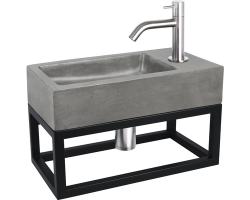 Wastafel van beton met stalen frame en waterkraan