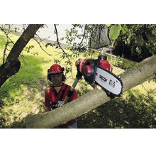 Man met helm zaagt boomstam met een kettingzaag op steel