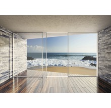 Lichte ruimte met stenen muur, houten vloer en glazen pui met uitzicht op zee