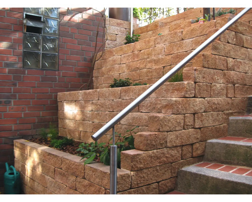 Trap met hellingversteviging van muurstenen en roestvrijstalen leuning