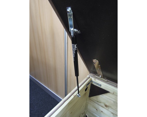 Detailopname van een houten kist met gasveer voor dekselondersteuning