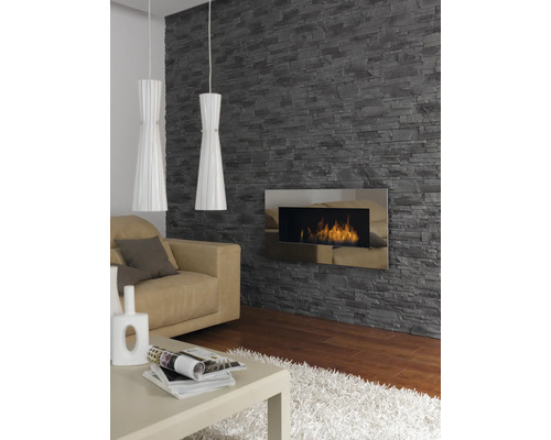 Woonkamer met steenbehang, open haard, bank, tafel en twee hanglampen