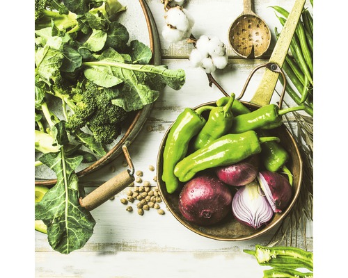 Stilleven met verse groenten, waaronder broccoli, paprika''s en uien, gerangschikt in kommen en op een houten oppervlak.