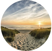 Een pad door zandduinen naar het strand bij zonsondergang