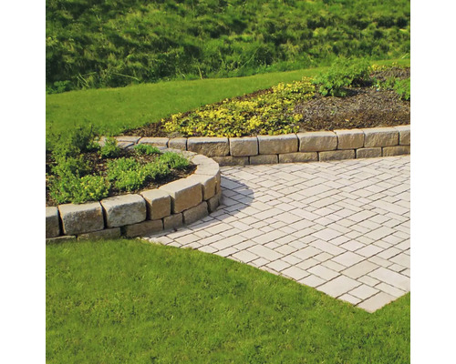 Tuin met bestrating en natuurstenen muur