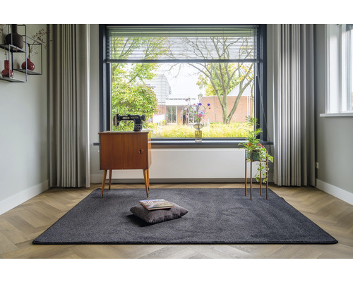 Grijs tapijt in woonkamer met naaimachine en raam