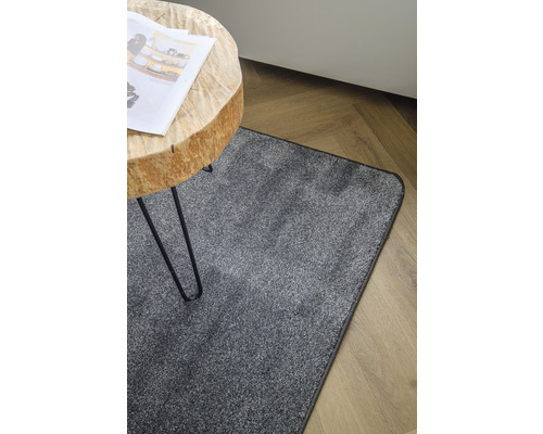 Grijs tapijt onder een houten tafel op een houten vloer