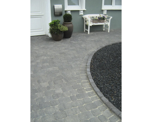 Buitenfoto van een huis met een bestrate oprit en decoratief grind