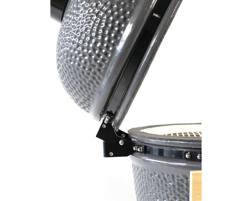 Detailopname van een keramische barbecue met open deksel en scharnier.