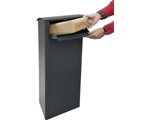 Persoon plaatst een zending in een pakketbrievenbus.