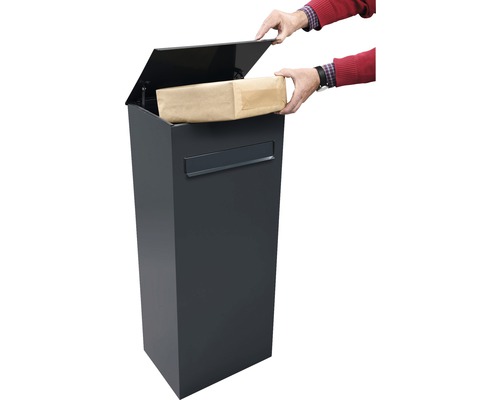 Persoon plaatst een pakket in een antracietkleurige pakketbrievenbus