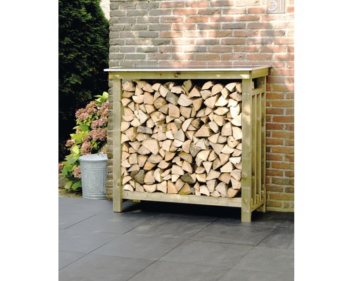 Houtopslag met brandhout voor een bakstenen muur