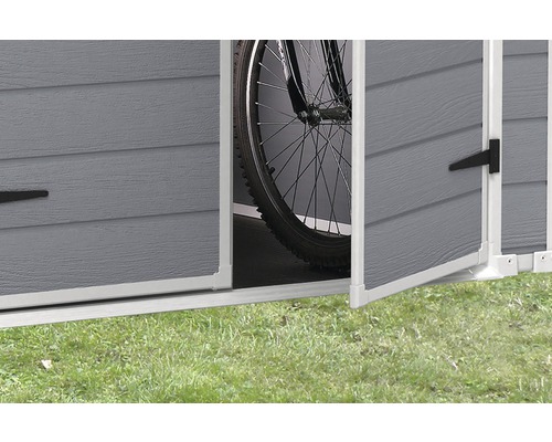 Detail van een open tuinhuisje met een fiets erin.