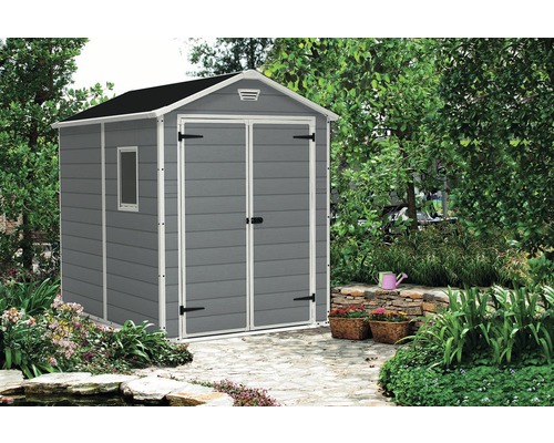 Grijze tuinhuis met raam in de tuin