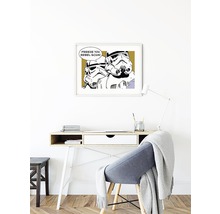 Een werkkamer met een bureau, een stoel en een ingelijste Star Wars print aan de muur.