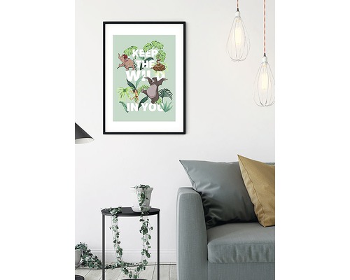 Ingelijste poster met Jungle Book-motief en de tekst ''Keep the wild in you'' in een woonkamer