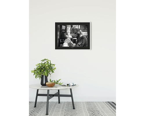 Zwart-witfoto van een koppel in een lijst boven een tafel