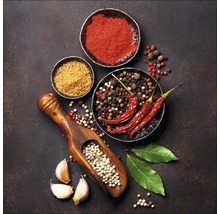 Arrangement van diverse kruiden en specerijen, waaronder chilipepers, peper en teentjes knoflook